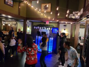People sing with the karaoke dj and dance at the Golden Road Brewery Christmas party with a photo booth