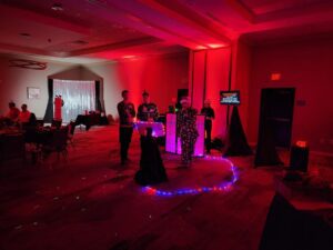 Karaoke Dj, Client staff test out microphones, photo booth with the up lights in a dimly lit room